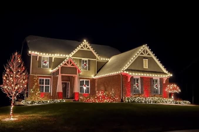 Warm-white C7 and C9 roofline lights installed on a red two-story home