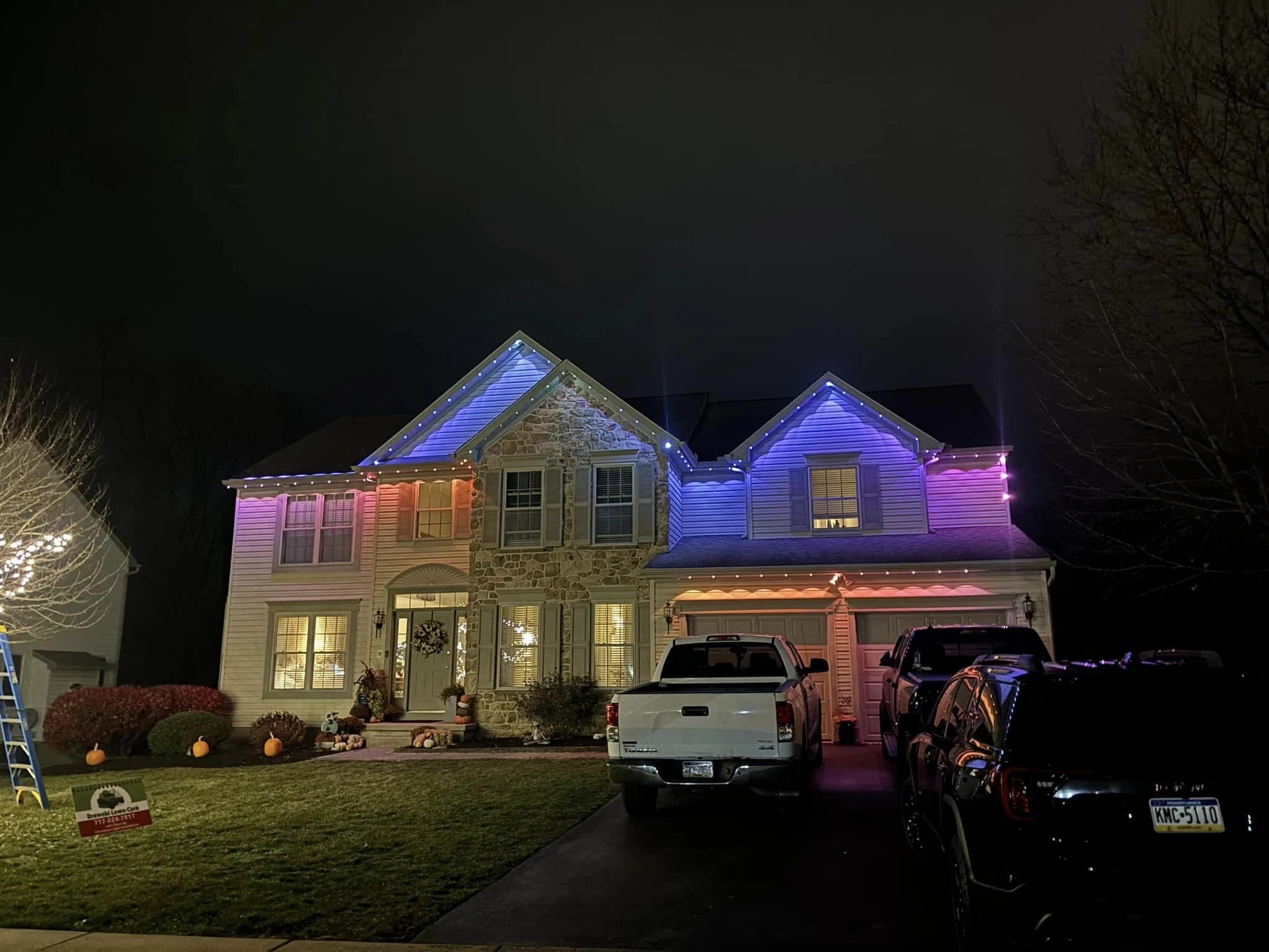 Blue and purple permanent RGBW pixel lights installed on a two-story home